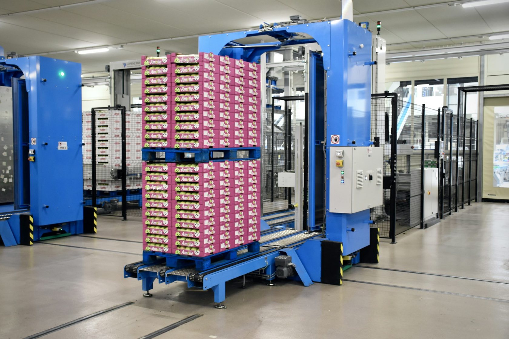 Paletizador automático apilando cajas de fruta en una planta de empaque