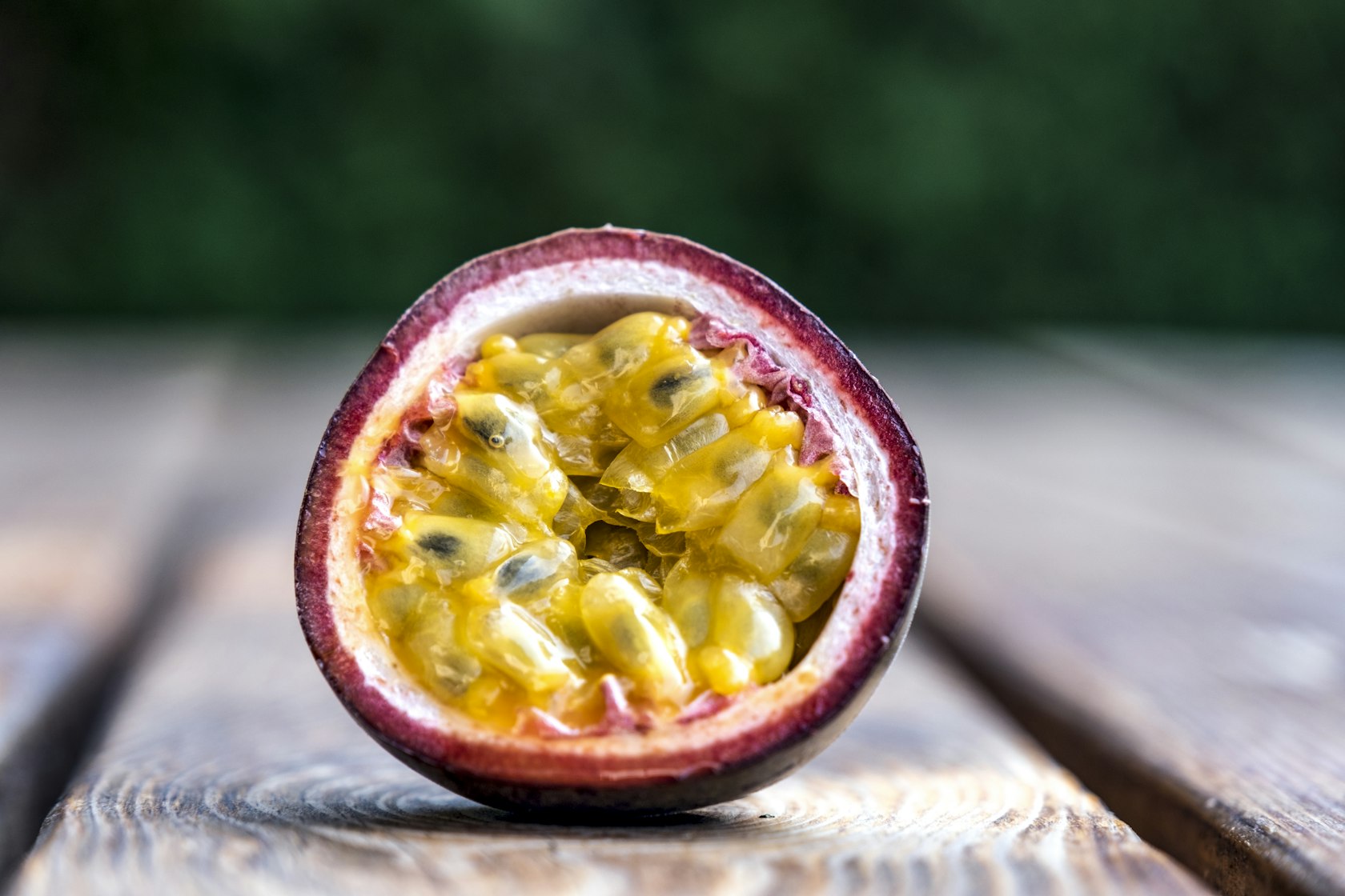 A halved passion fruit showing pulp and seeds