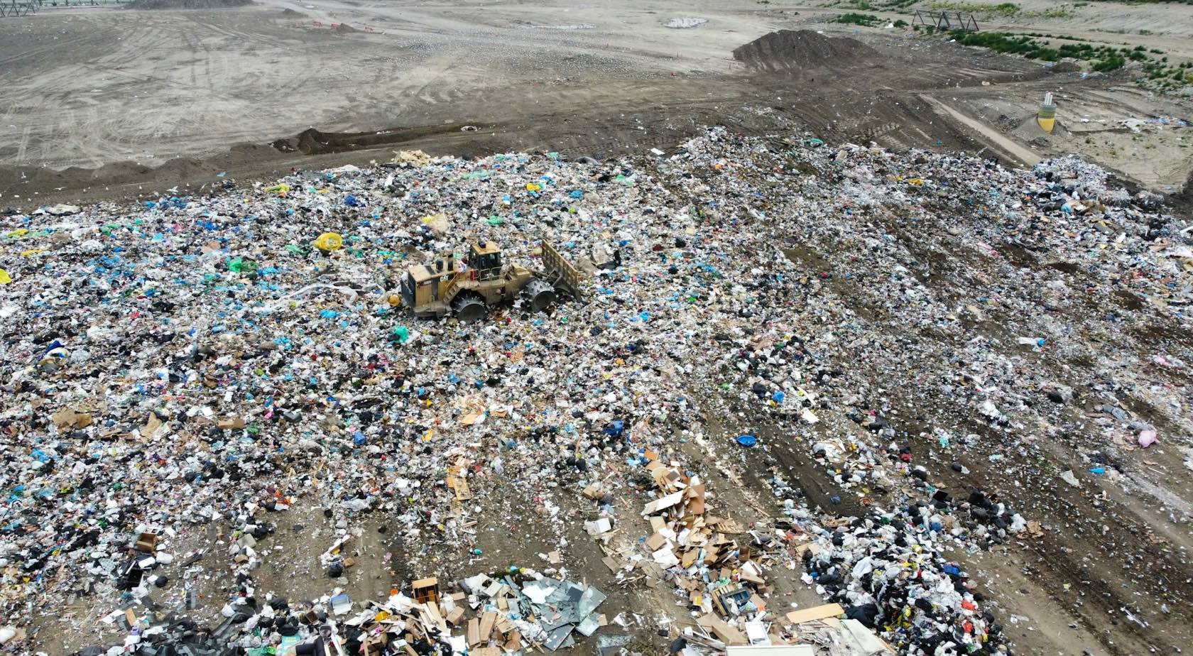 Vista aérea del frente de trabajo de un relleno sanitario con compactadora